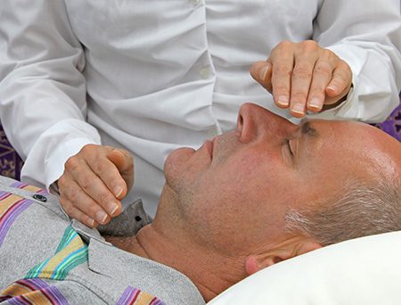 A man receiving reiki energy therapy
